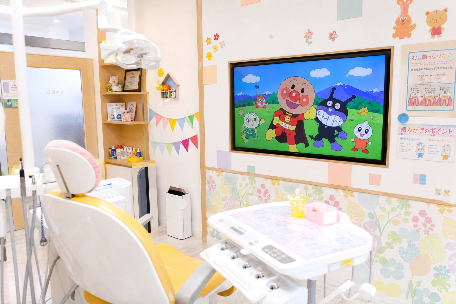 プロンプト：診察台の前に大きなアニメモニターが設置された、カラフルで明るい小児歯科の診察室の写真。